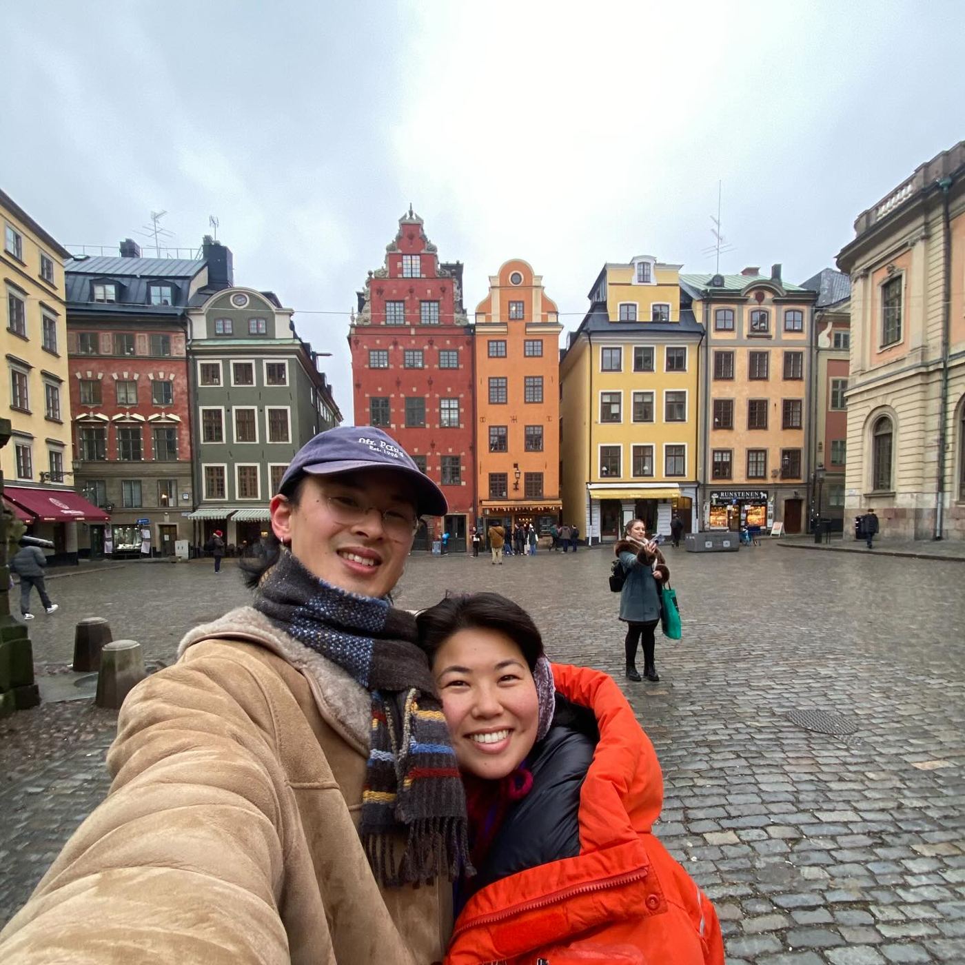 Ryo and Maria smiling together in a cobblestone square in Stockholm's old town