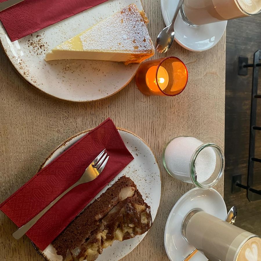 Cake and coffee on a café table by candlelight