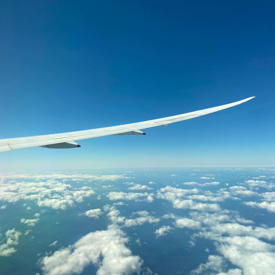 A plane wing over a sea of clouds